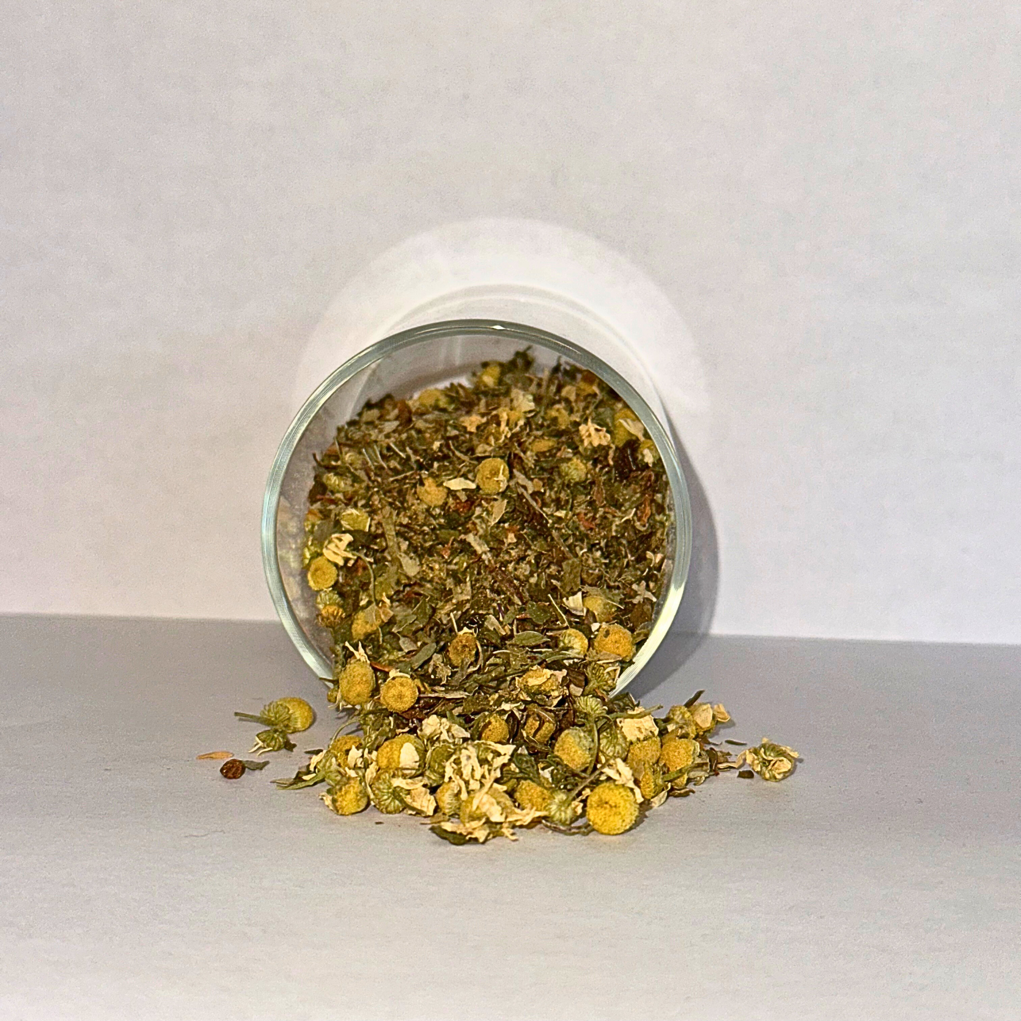 Spilling dried herbs from a glass jar